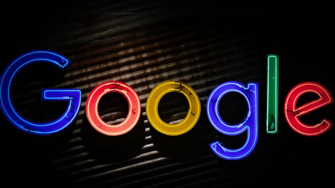 Google logo neon sign as the company announces a restructuring of its divisions and leadership to accelerate its AI initiatives.